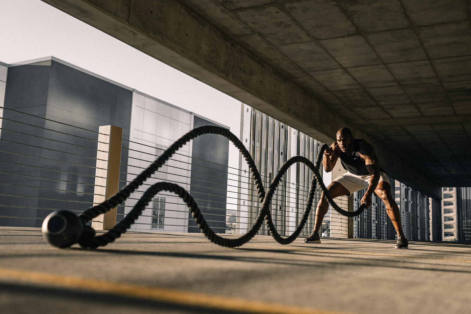 man exercising with battle ropes outdoors